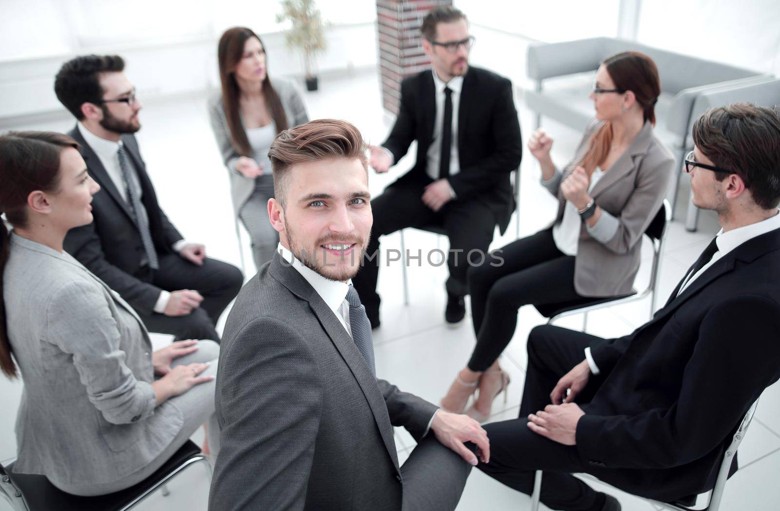 young employee sitting in a circle with business team.the concept of team building
