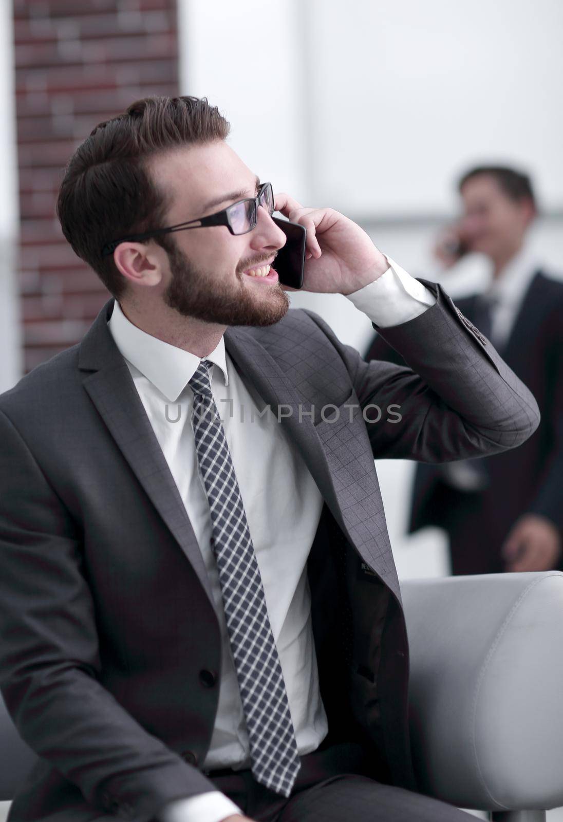 Charming businessman talking on phone in a modern building by asdf