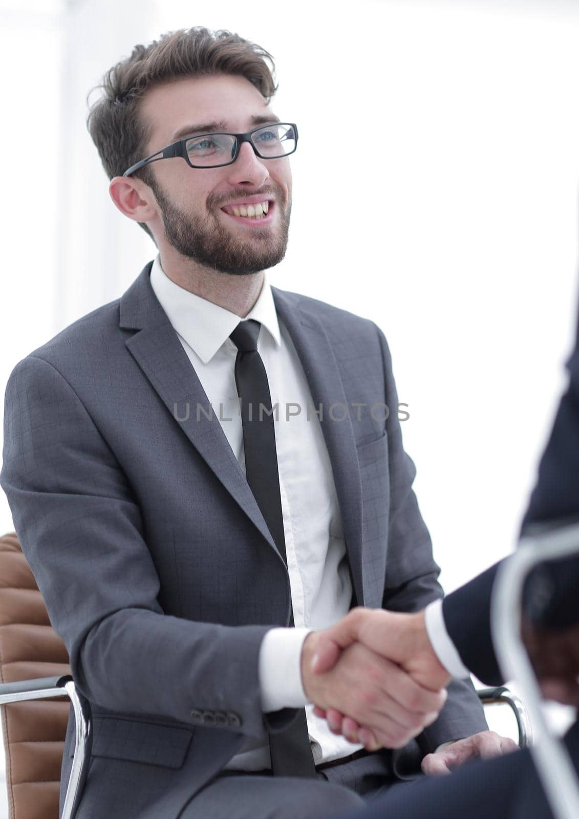 Image of two young businessmen interacting at meeting in office