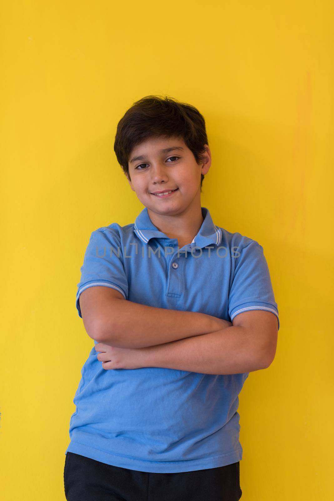 Portrait of a happy young boy in front of colored background