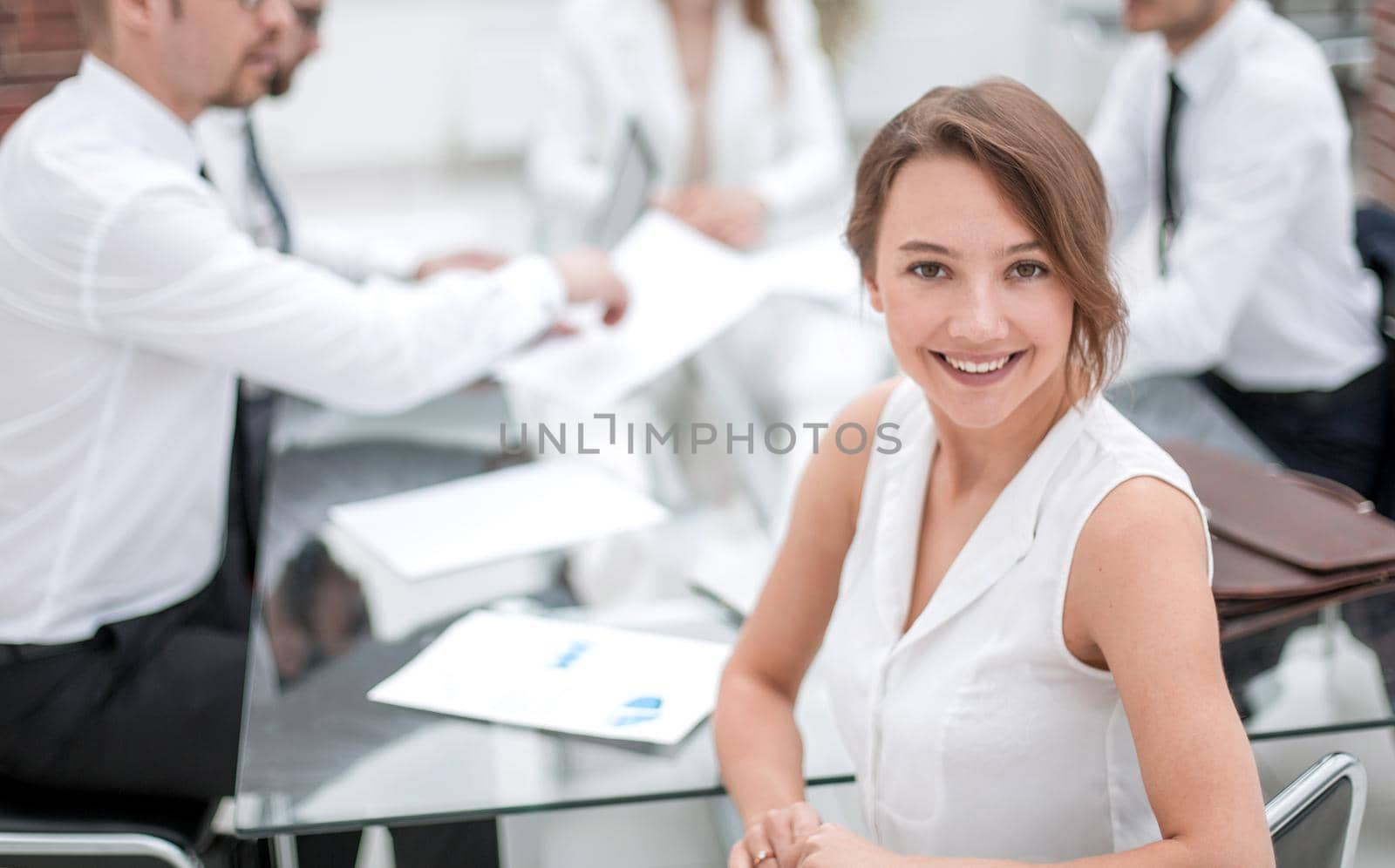 smiling business woman sitting in front of Desk by asdf