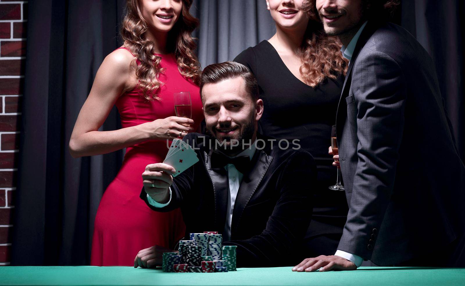 A man, accompanied by a woman, shows four aces in poker