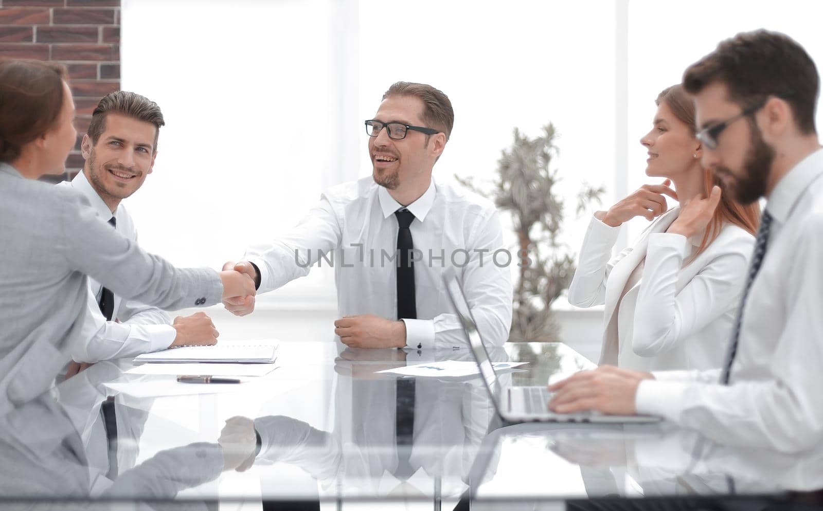 Manager shaking hands with a young business woman by asdf