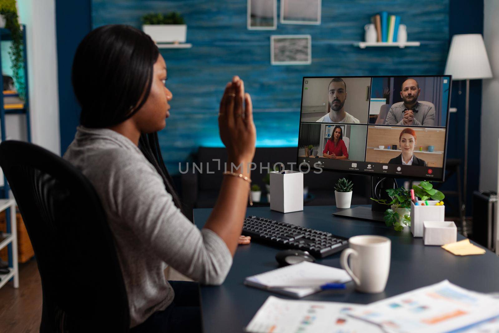 Employee talking to colleagues on video call to do teamwork on project. Woman doing business meeting on online remote conference, working from home and using computer. Video communication