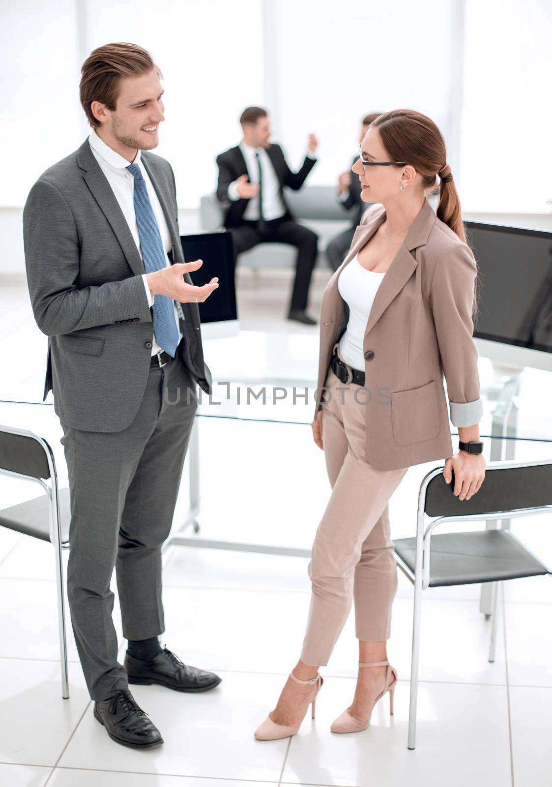 businessman and business woman standing in office talking with the receptionist.business concep
