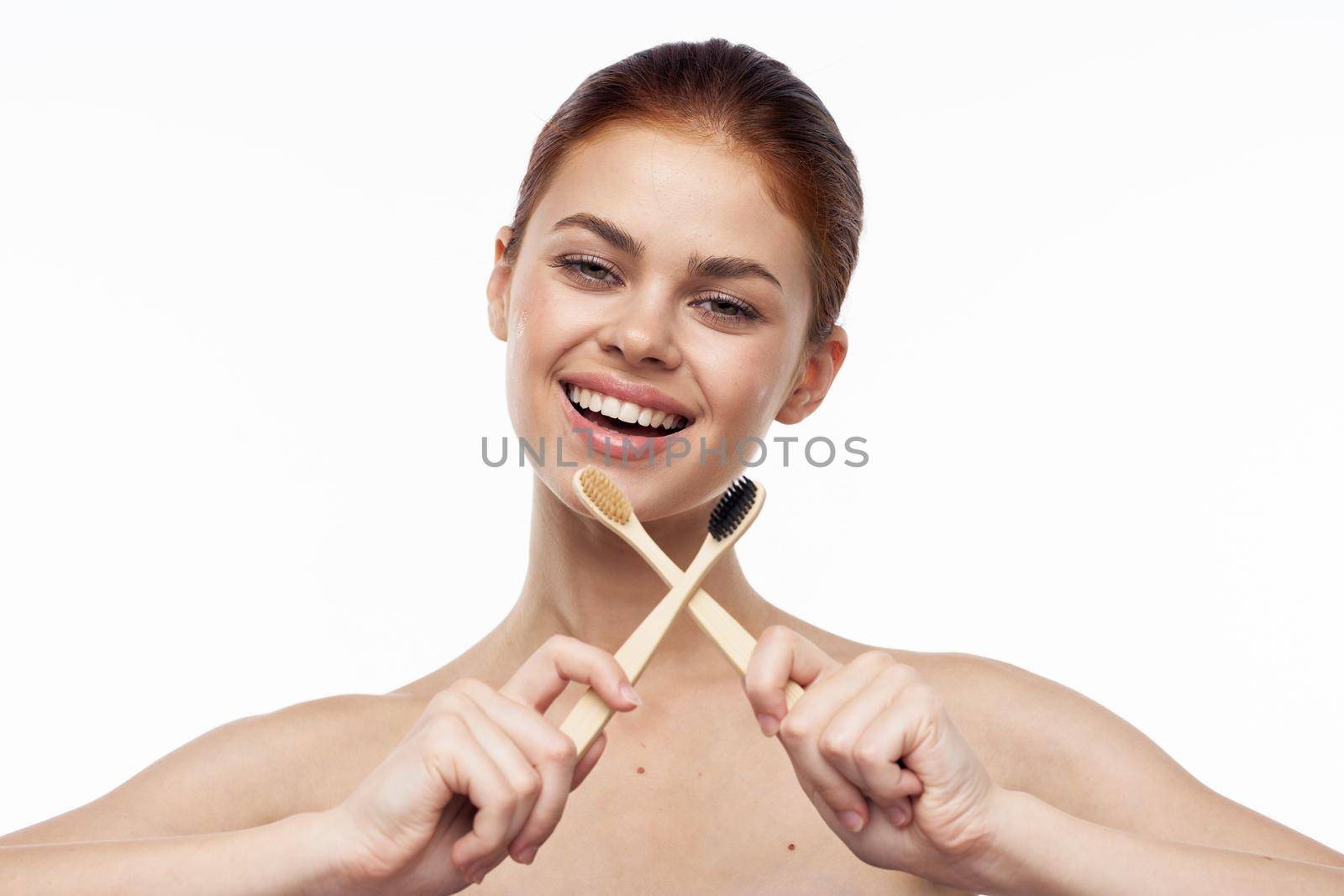 cheerful woman with bare shoulders toothbrushes hygiene oral care. High quality photo