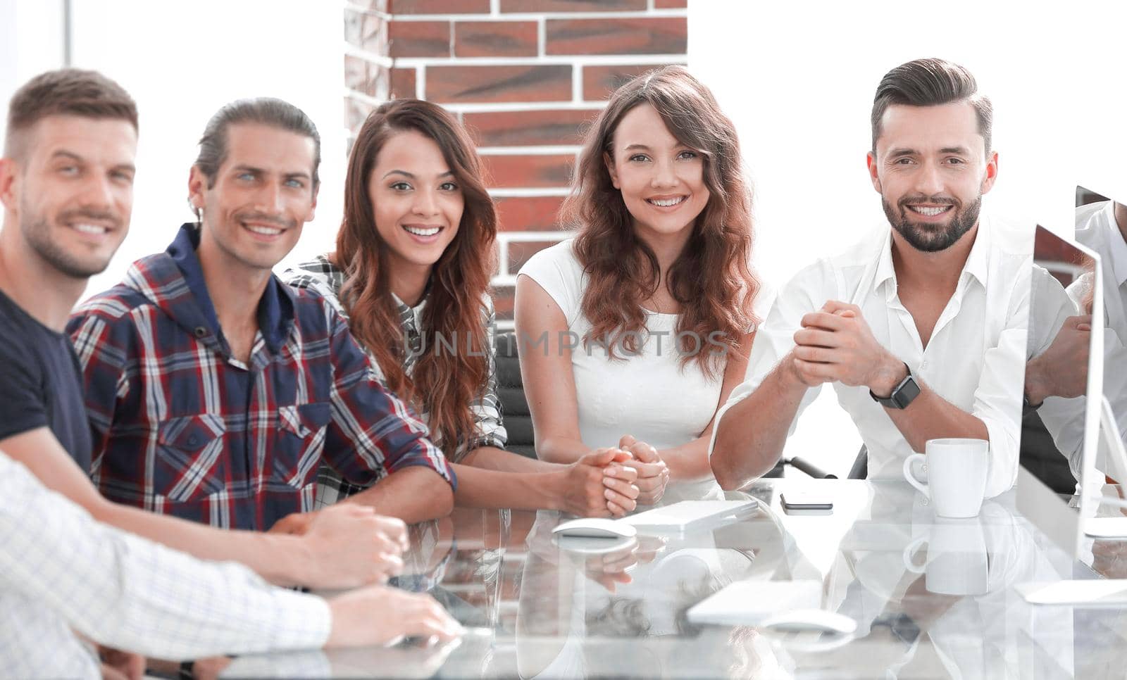 portrait of a successful creative team, sitting behind a Desk