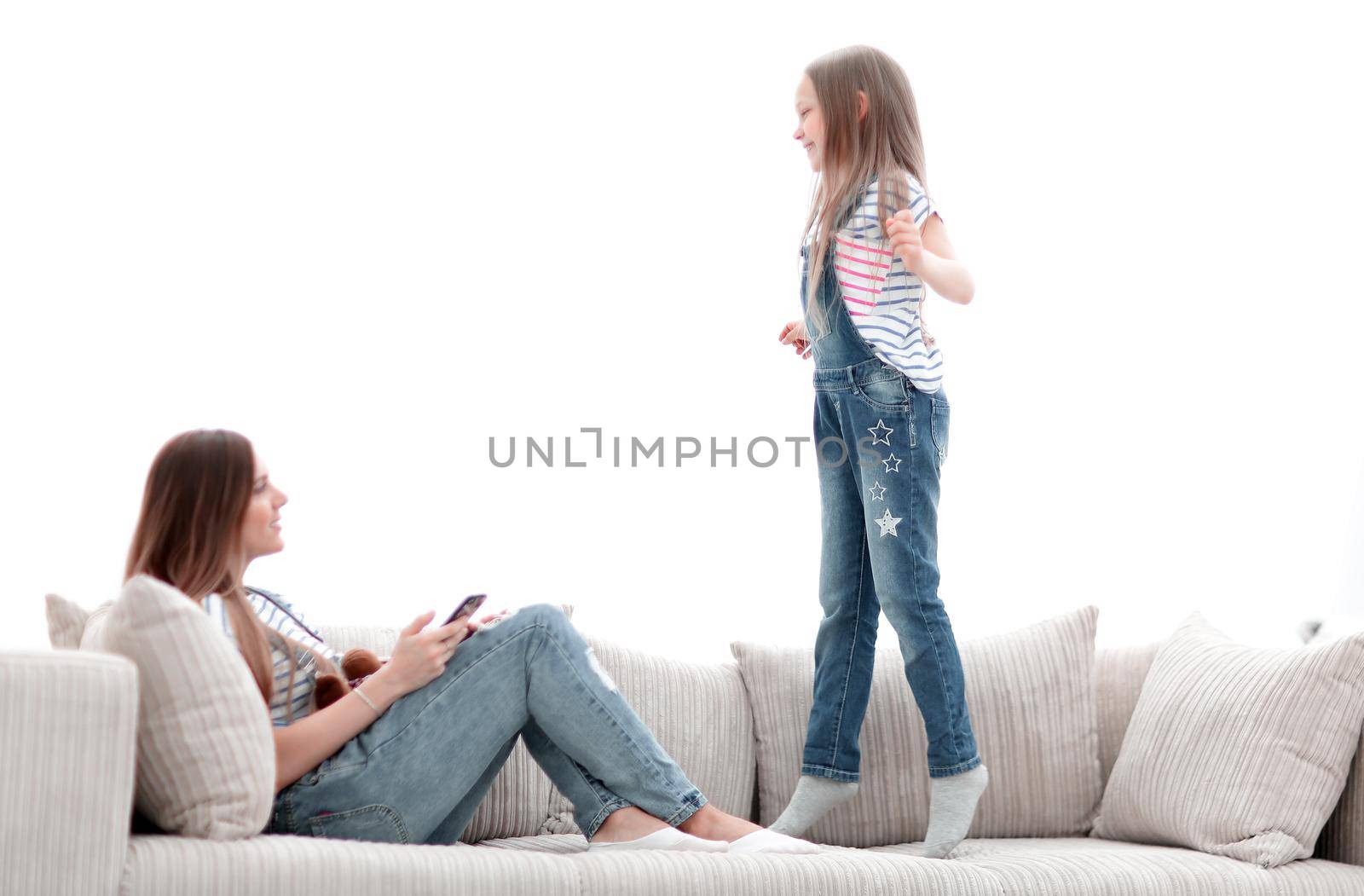 little girl jumping on the couch on the couch in the living room.the concept of children's happiness