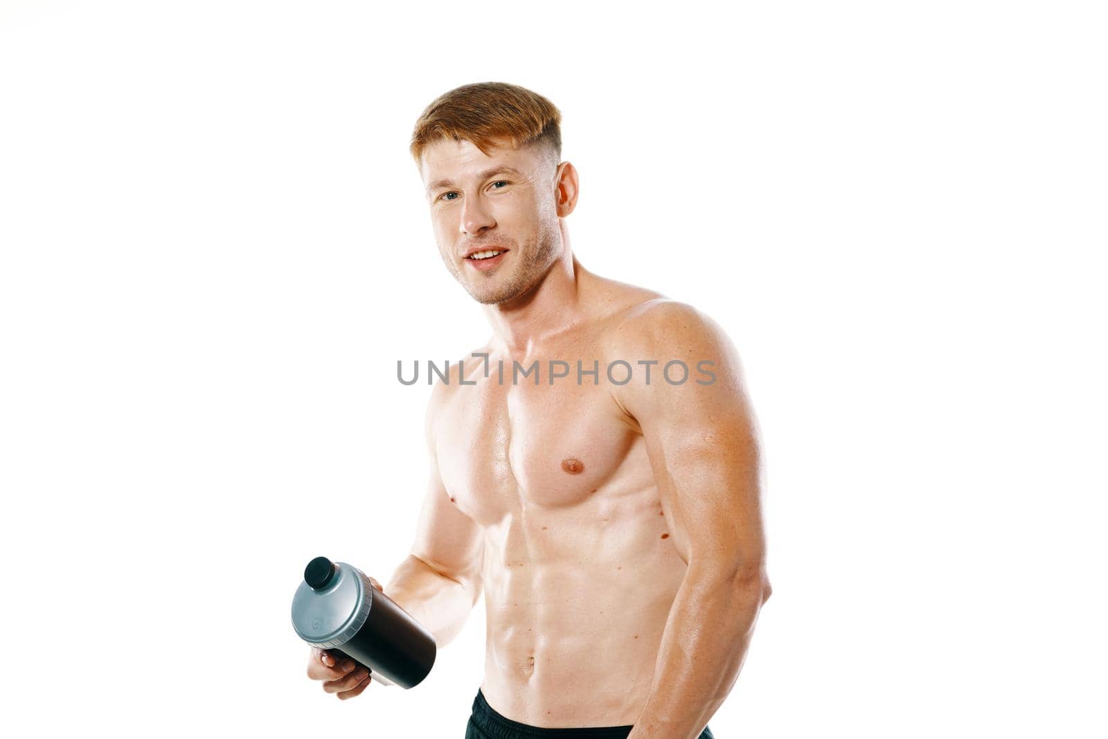 a man an athlete with a pumped-up body drinks from a bottle. High quality photo