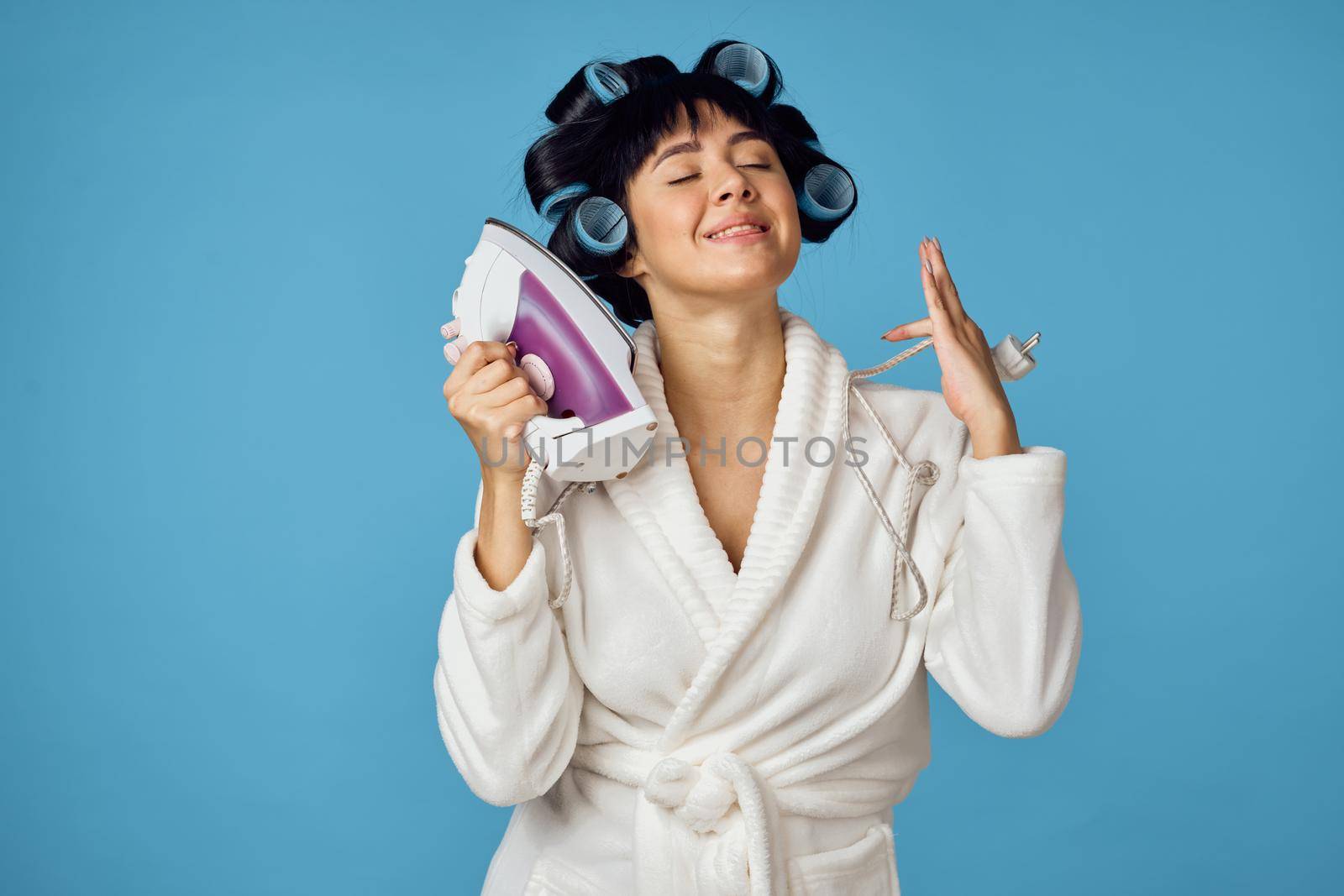 Woman in white robe housework cleaning service blue background. High quality photo