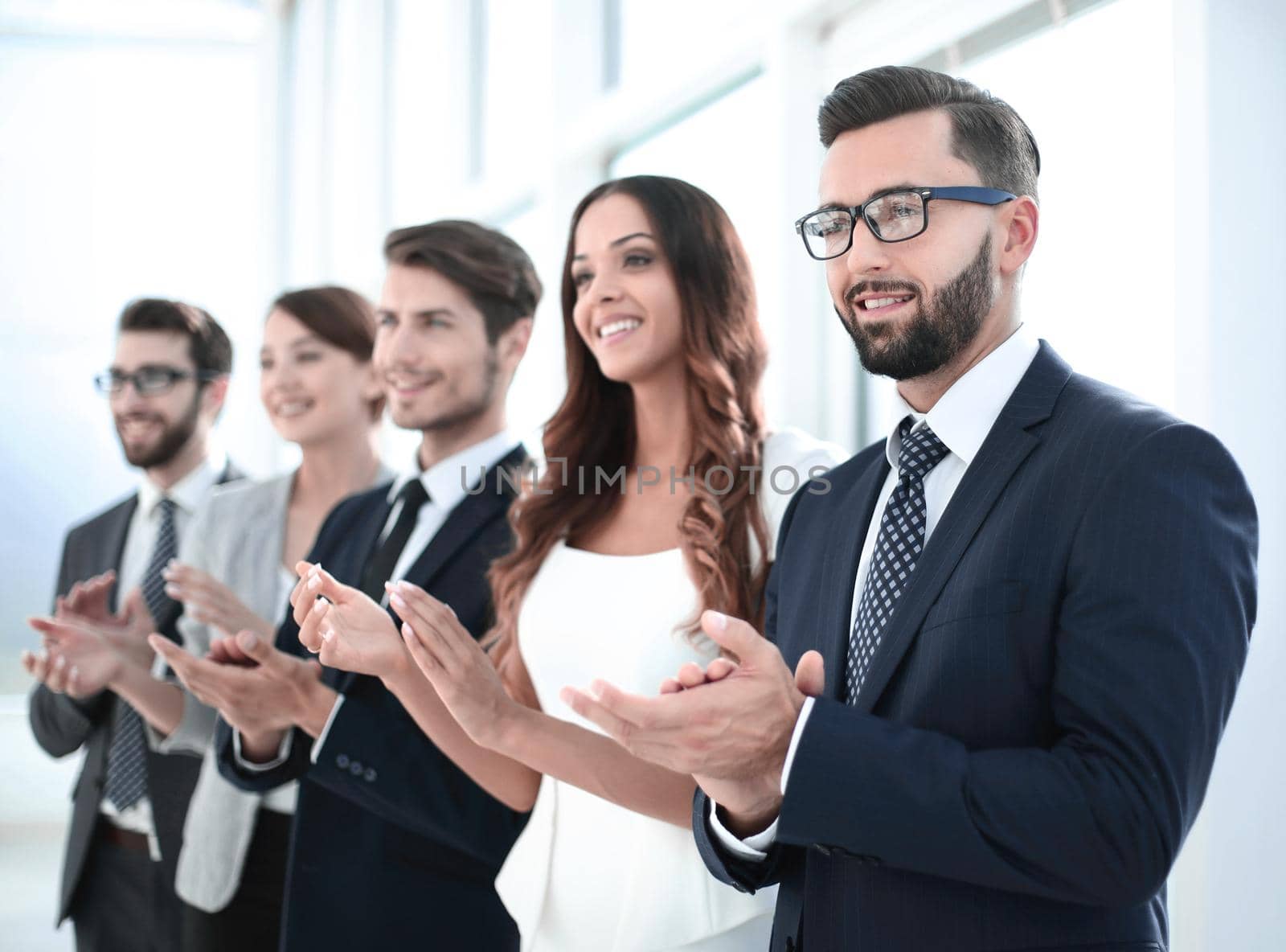 group of business people applauding someone standing in the offi by asdf