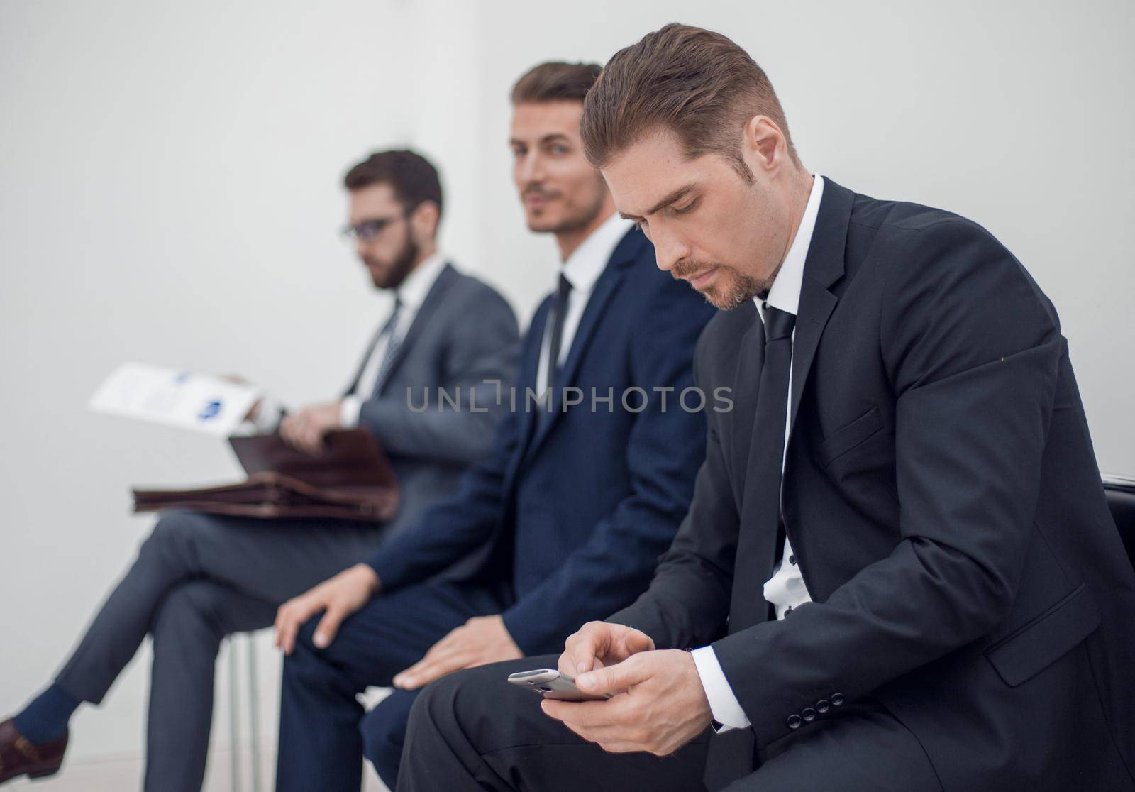 smiling businessman typing SMS on smartphone by asdf