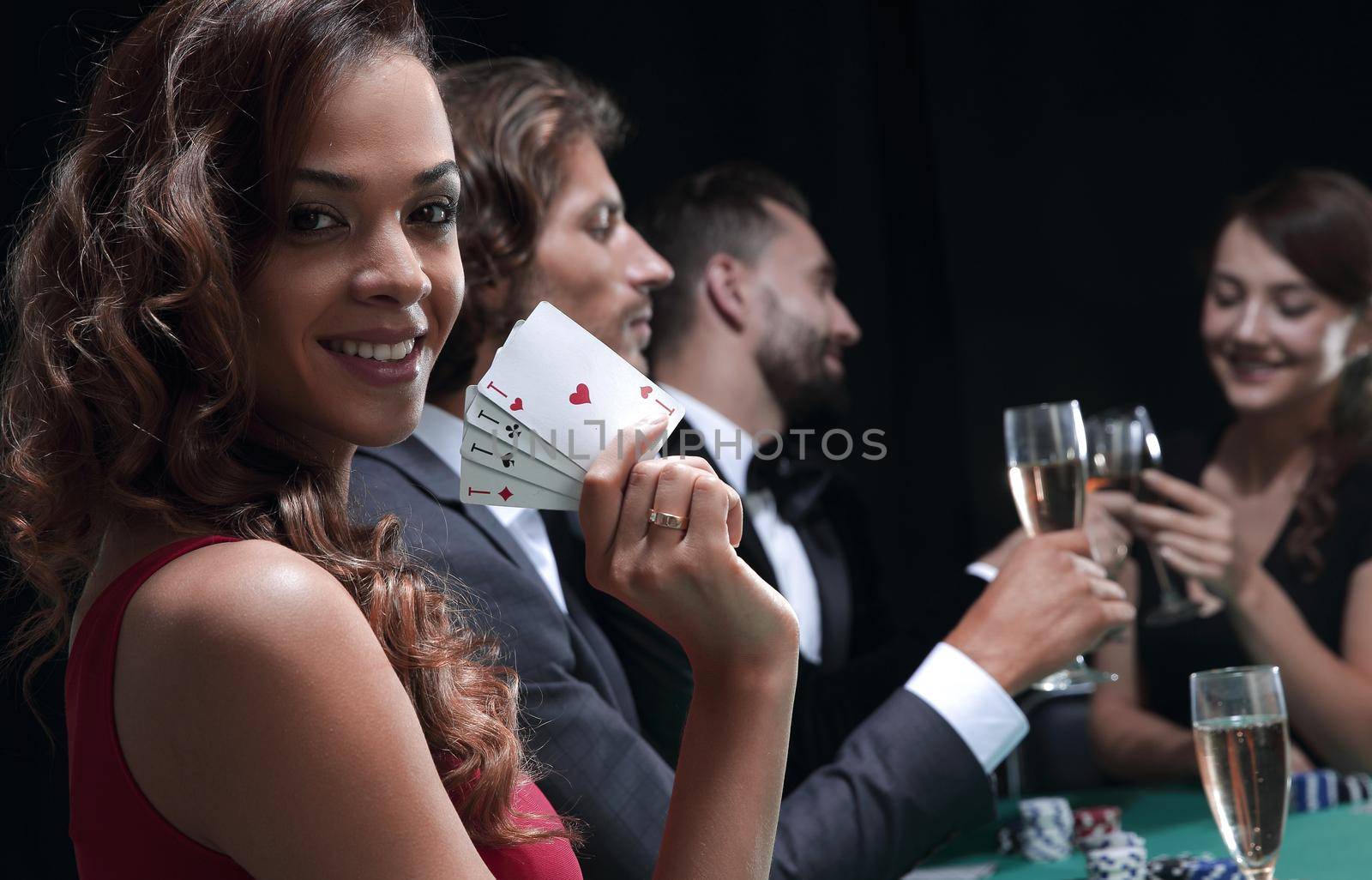 Smiling woman looking up from poker game in casino