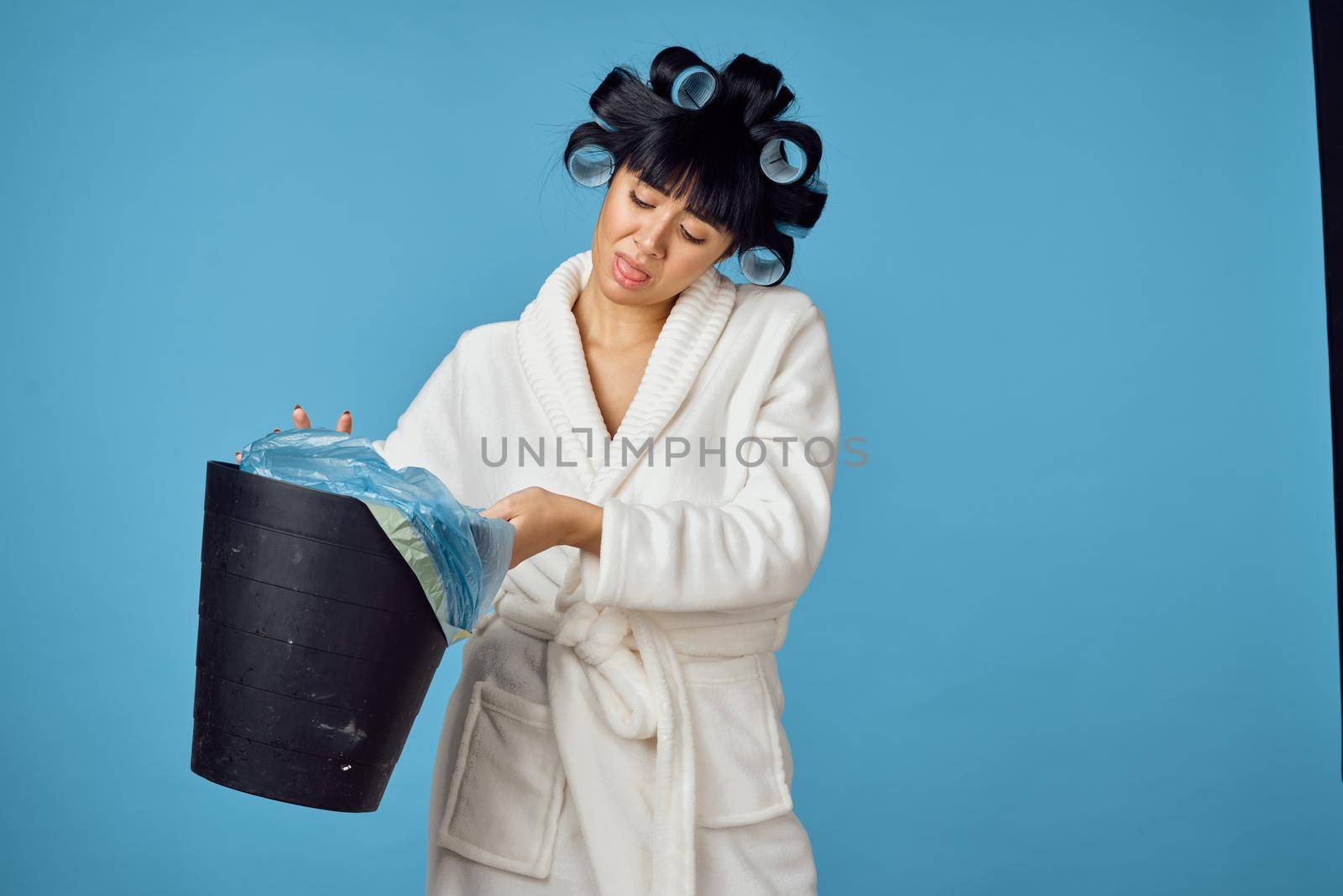 Woman in white robe housework cleaning service blue background. High quality photo