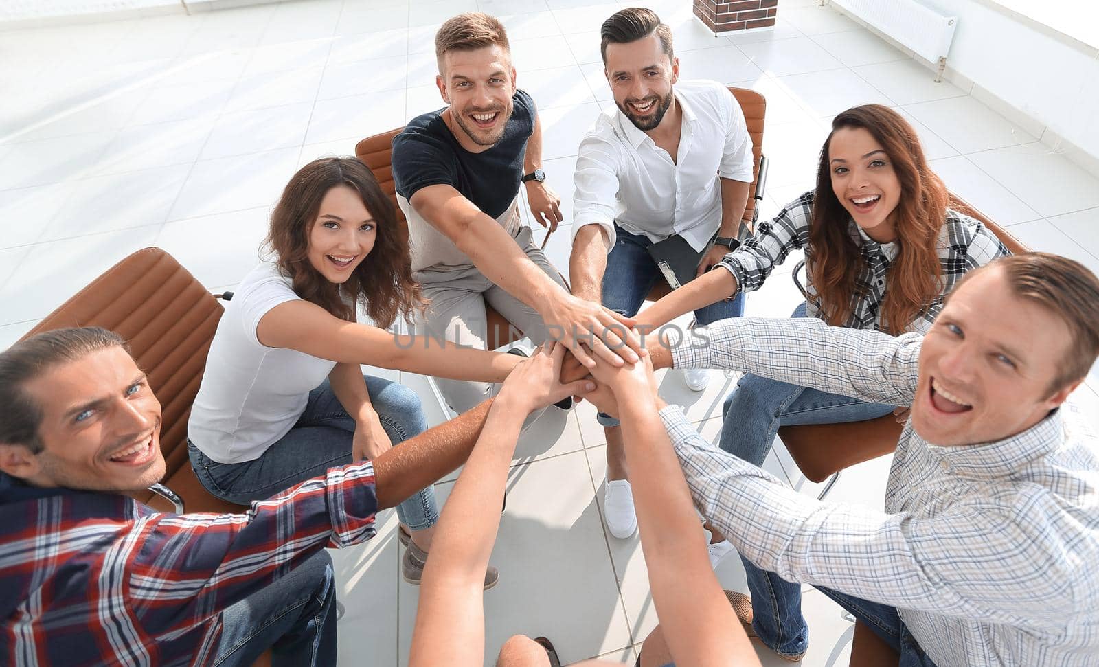 successful business team sitting in the middle of the office and hands clasped together