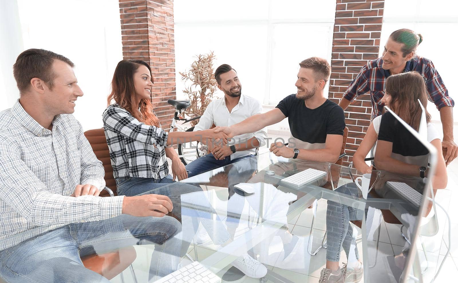 handshake of young designers at a meeting in creative office