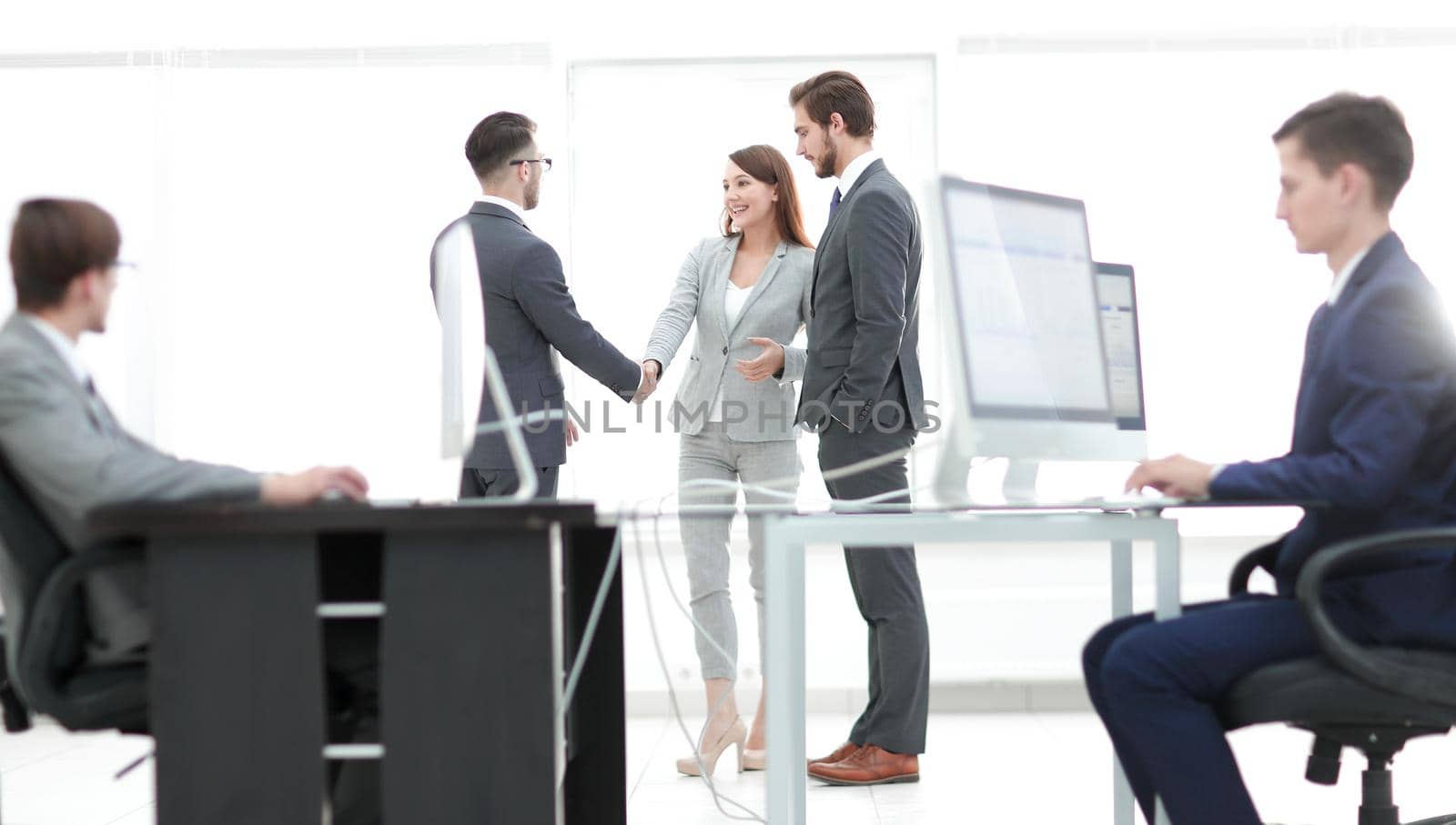 Businessman signing contract while his partner is looking at him in cosy meeting room