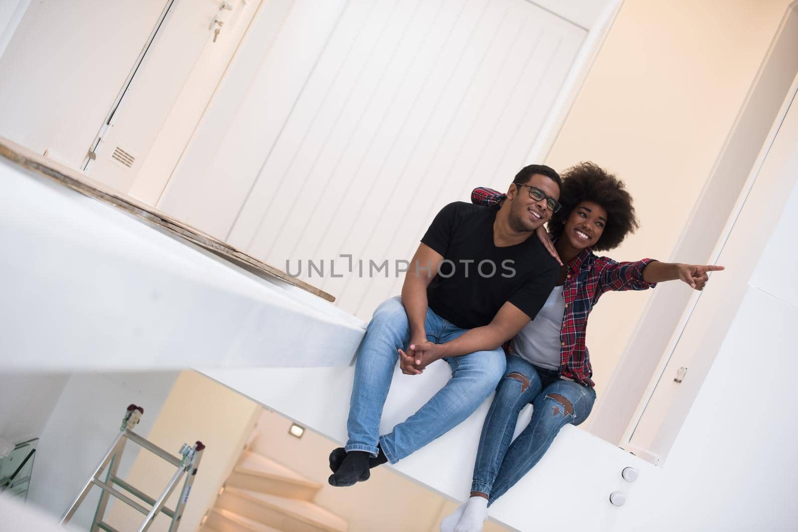 Happy young African American couple having break during moving to new house