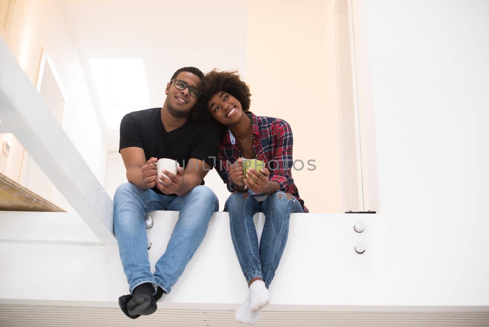 Happy young African American couple having break during moving to new house