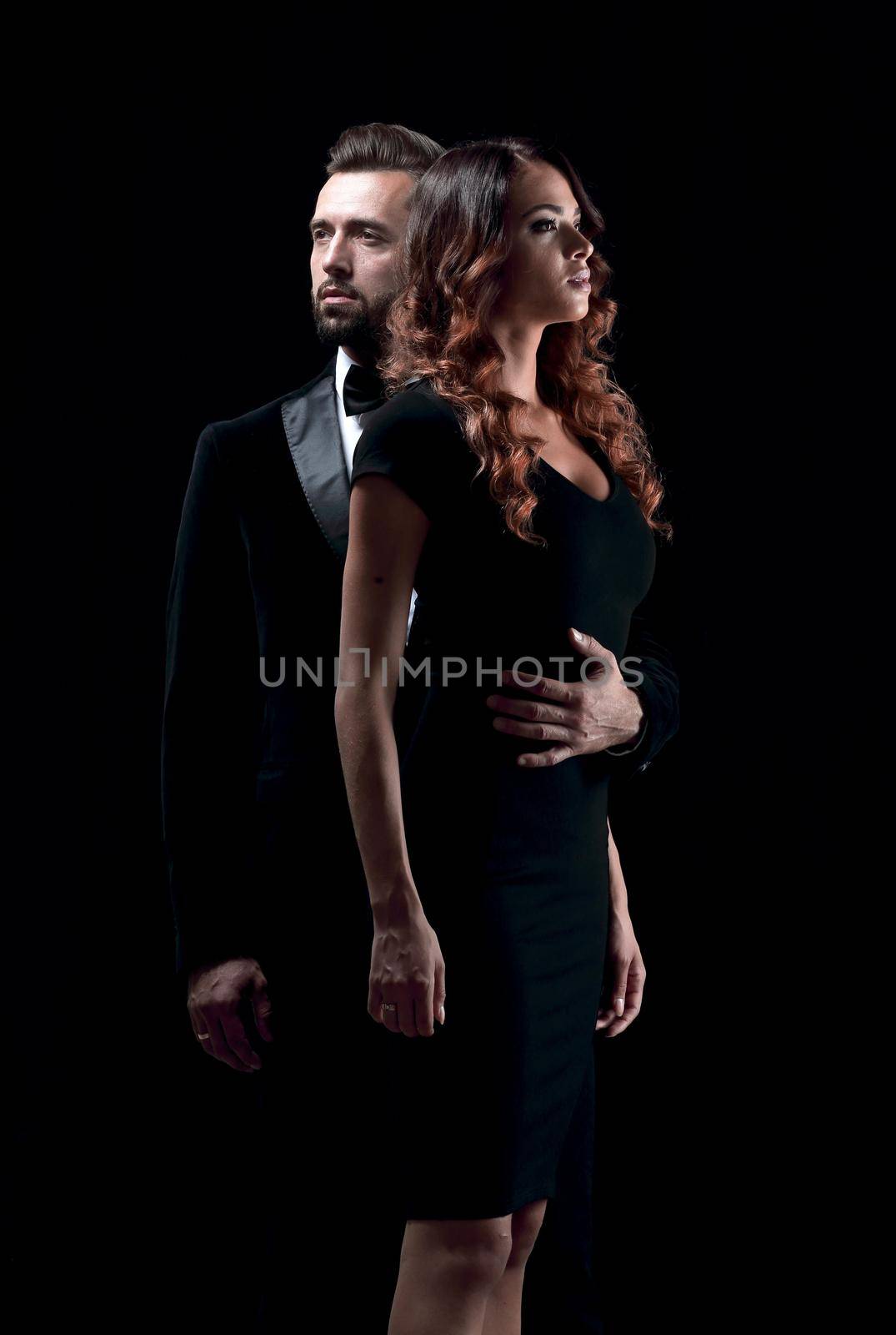 Full length picture of a young fashion couple standing on studio background.