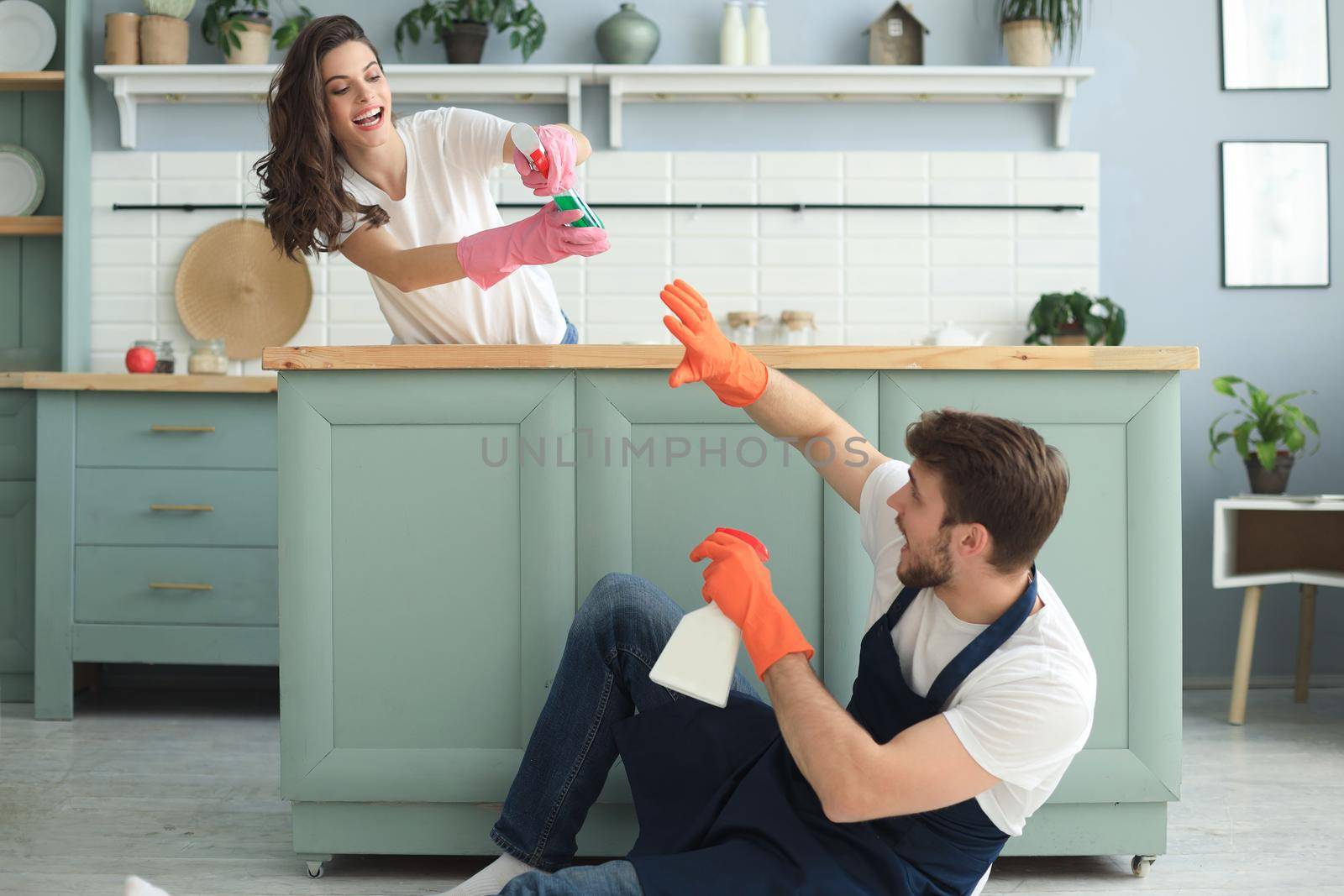 Young happy couple is having fun while doing cleaning at home