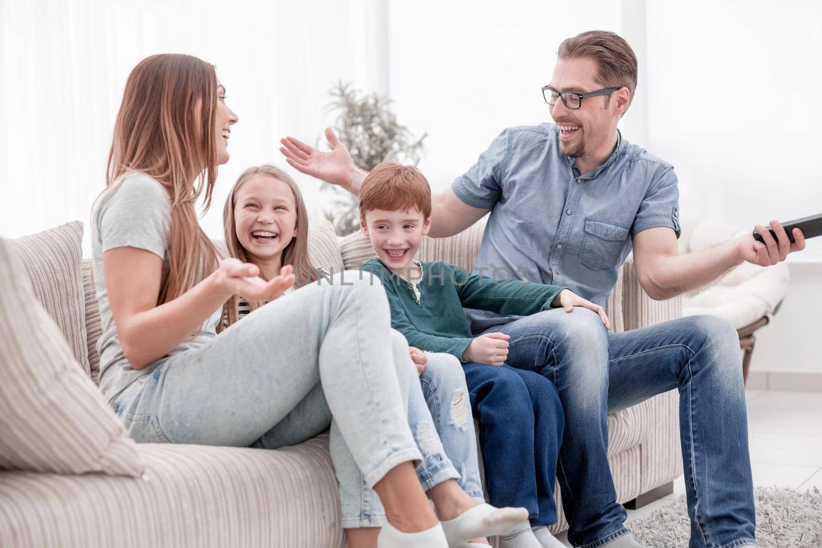 cheerful family sitting on the couch in the living room.the concept of family happiness
