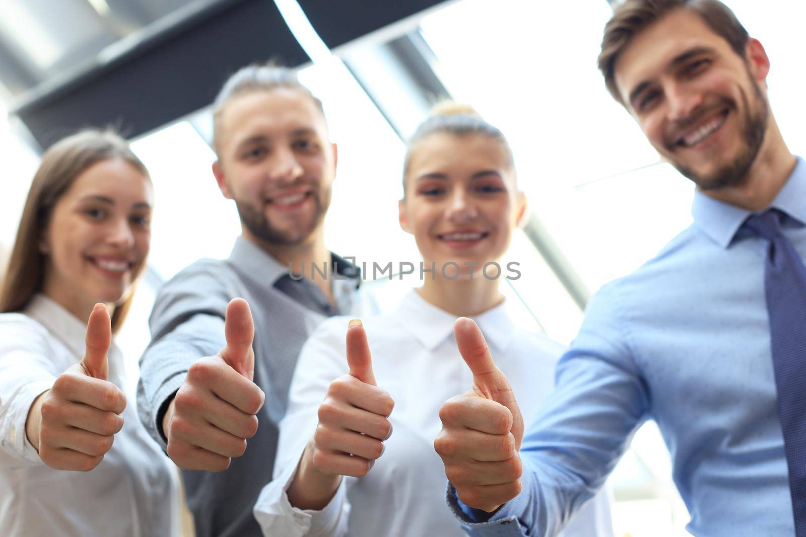 Successful business people with thumbs up and smiling. by tsyhun