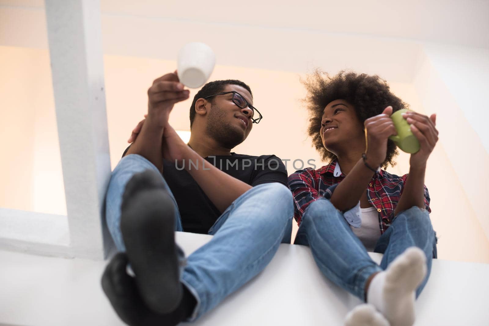 Happy young African American couple having break during moving to new house