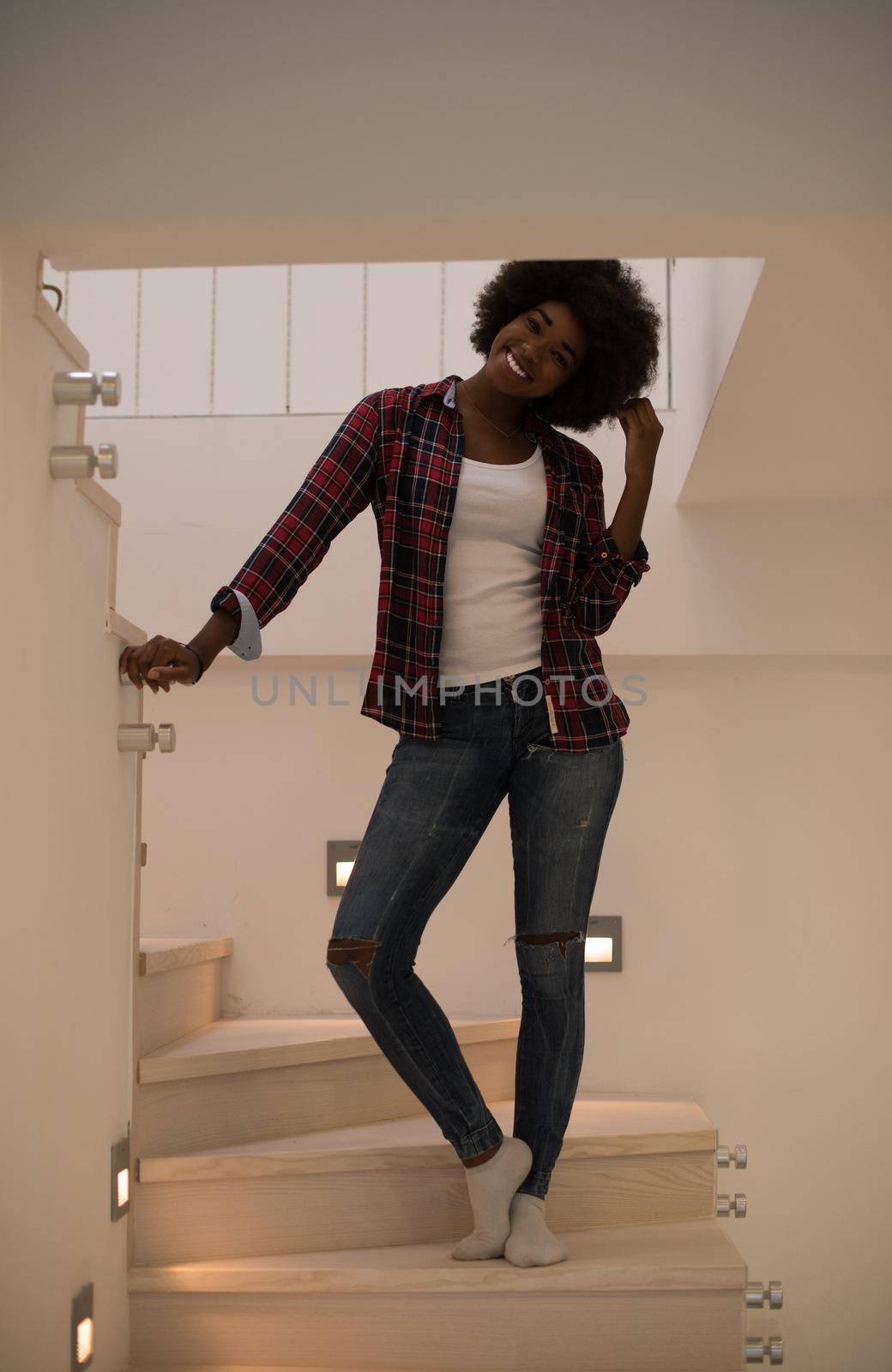 portrait of a beautiful young African American woman standing on the stairs in her luxurious home