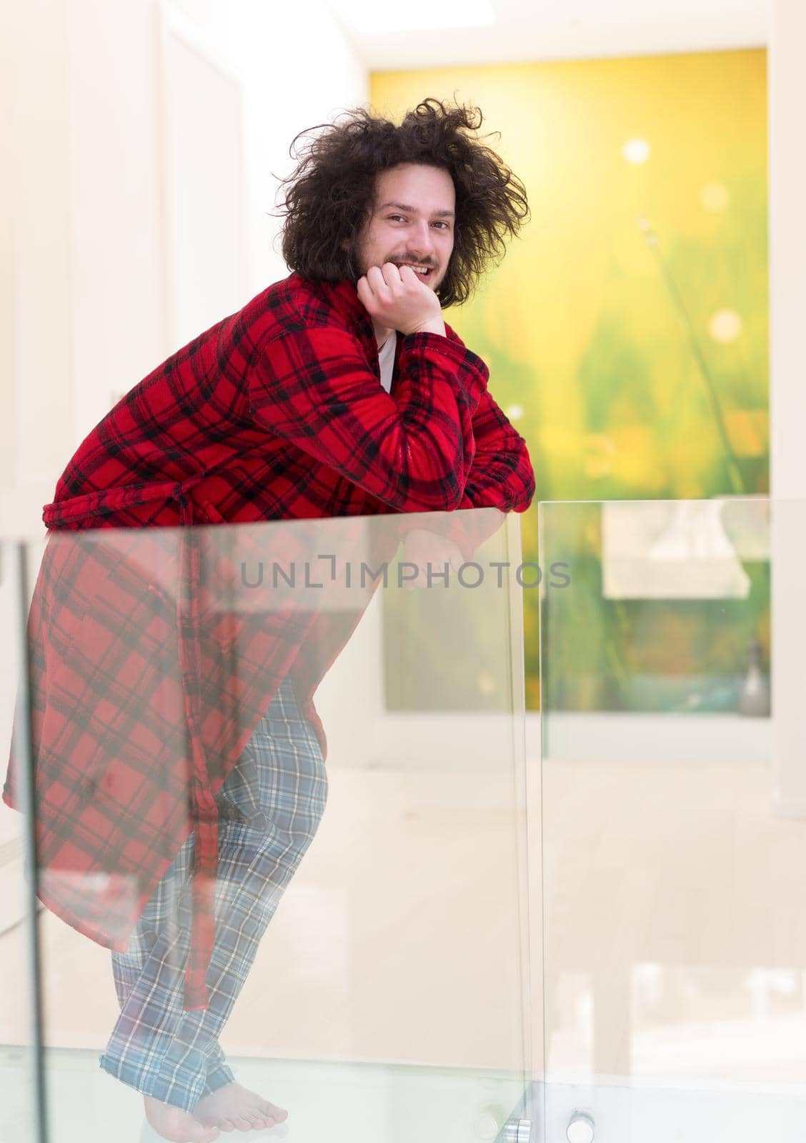 portrait of young man in bathrobe enjoying free time at home