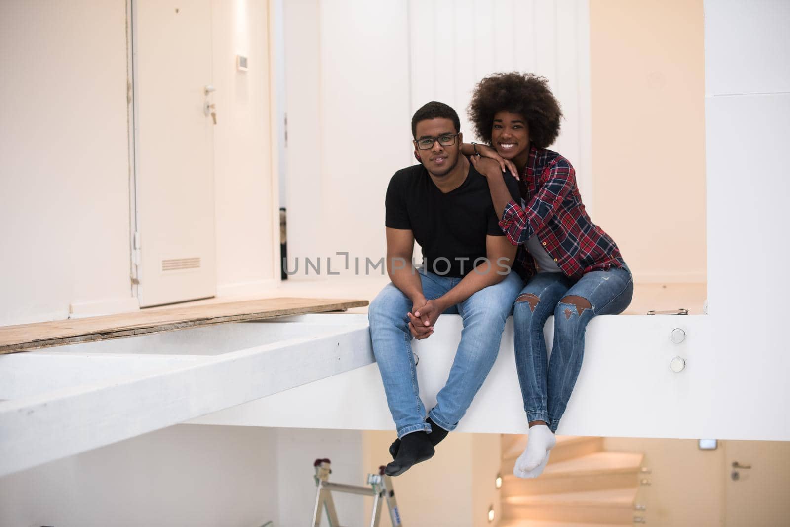 Happy young African American couple having break during moving to new house