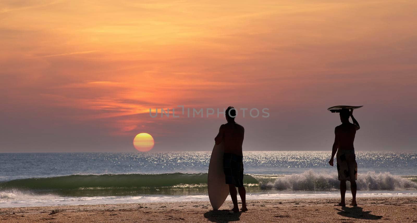 two surfers wainting for the wave in Cocoa Beach, Florida, usa, at sunset