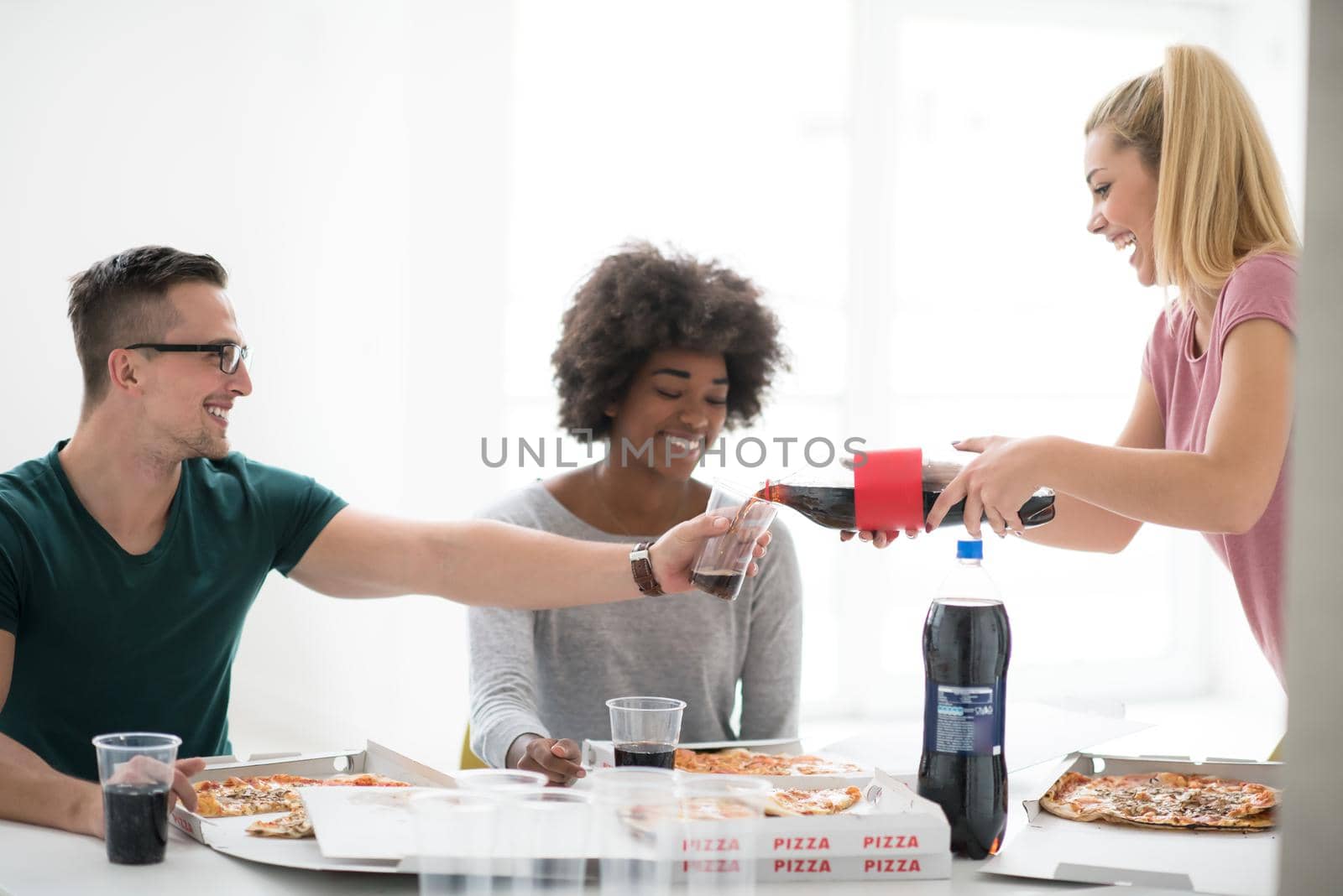 multiethnic group of young people have a lunch break after moving to a new home