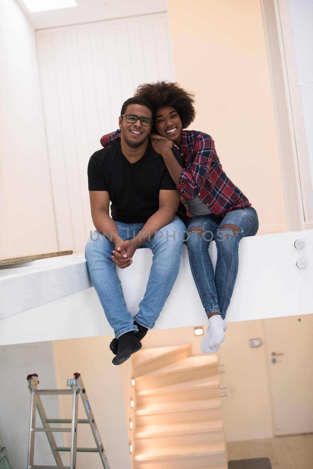 Happy young African American couple having break during moving to new house