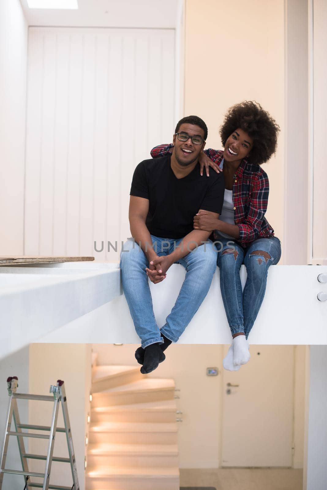 Happy young African American couple having break during moving to new house