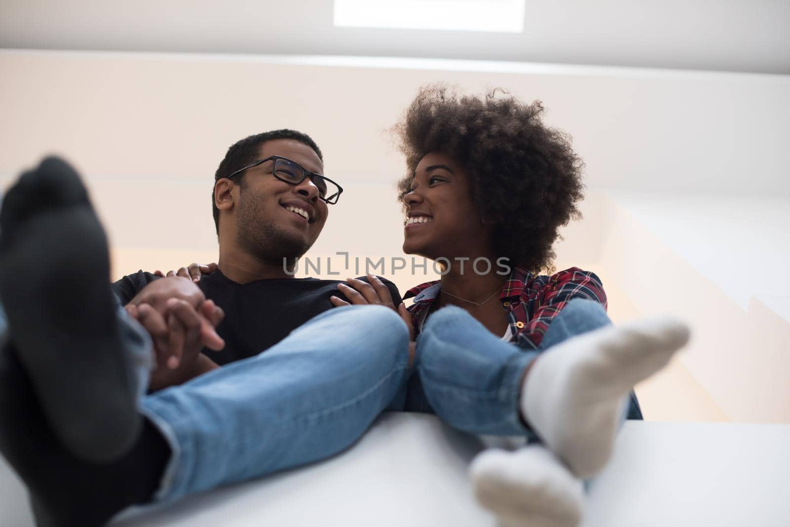 Happy young African American couple having break during moving to new house