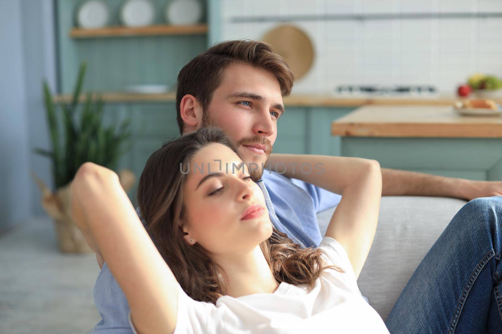 Portrait of cute young couple sitting in sofa