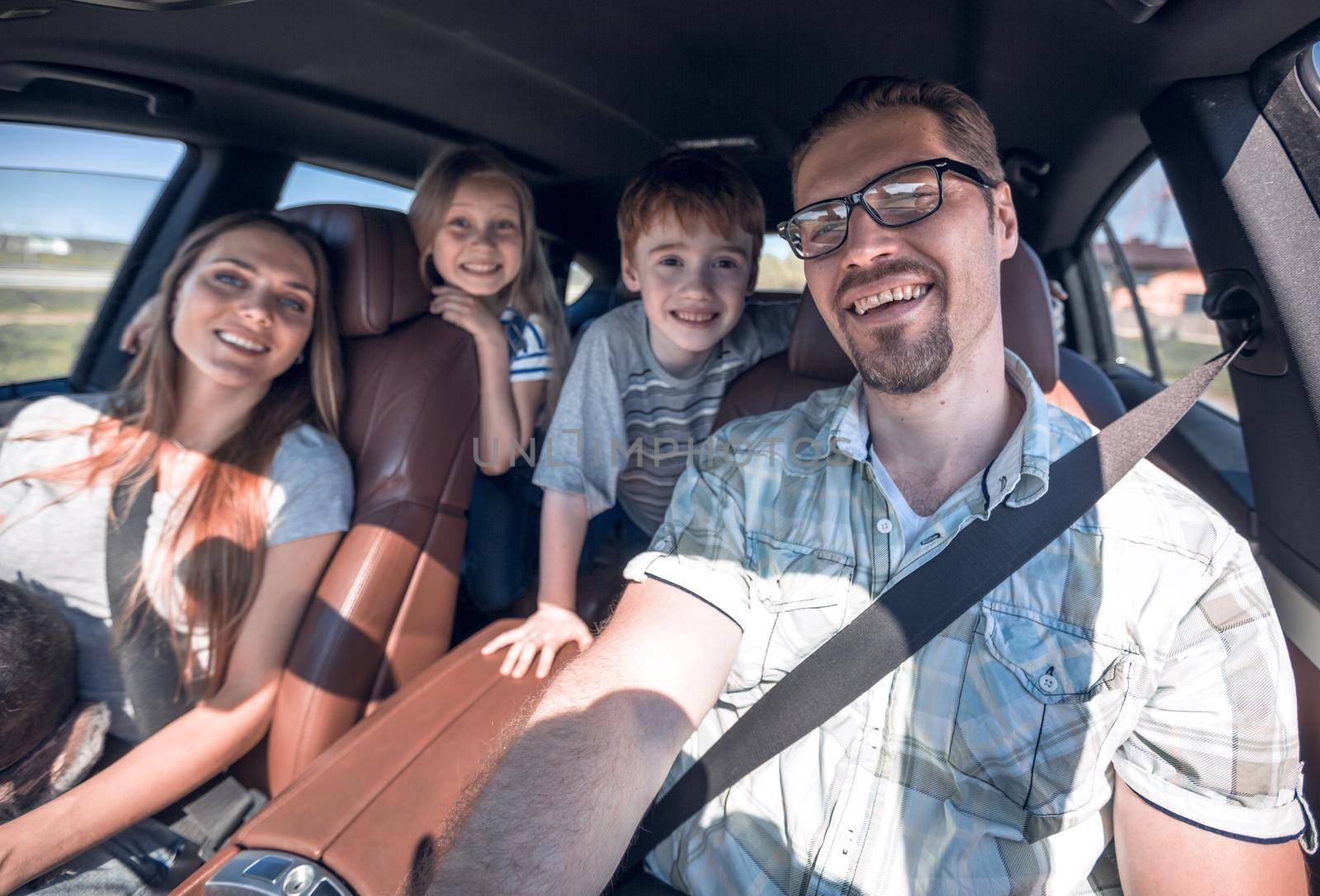 cheerful family with two children goes to the car by asdf