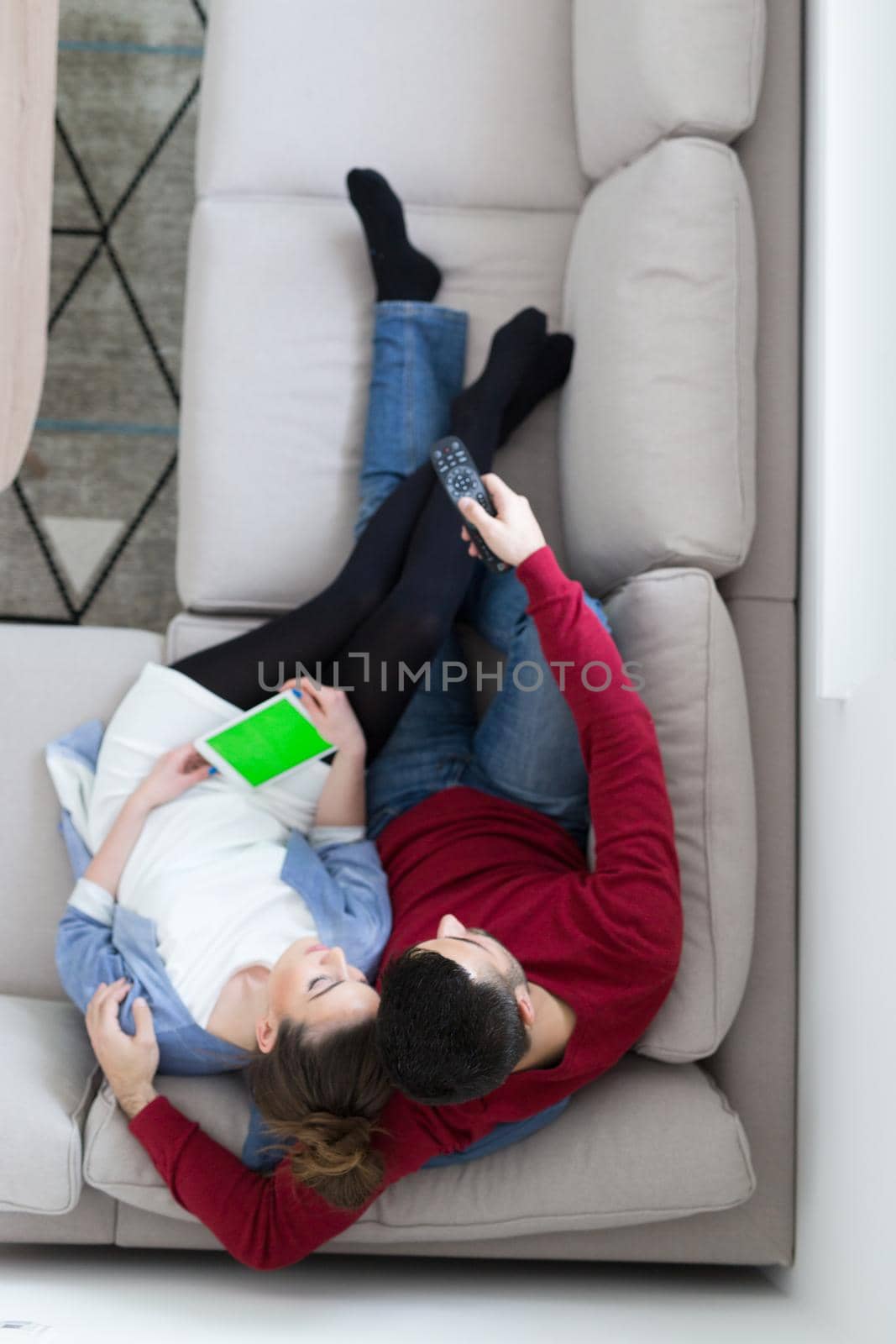 Young couple on the sofa watching television top view by dotshock