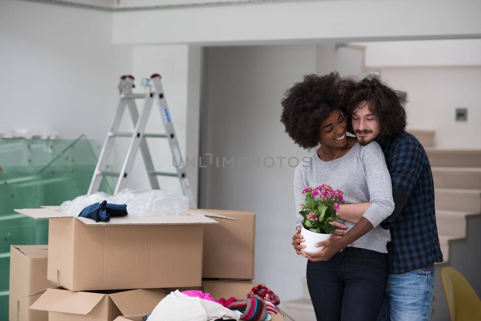 Happy young multiethnic couple unpacking or packing boxes and moving into a new home