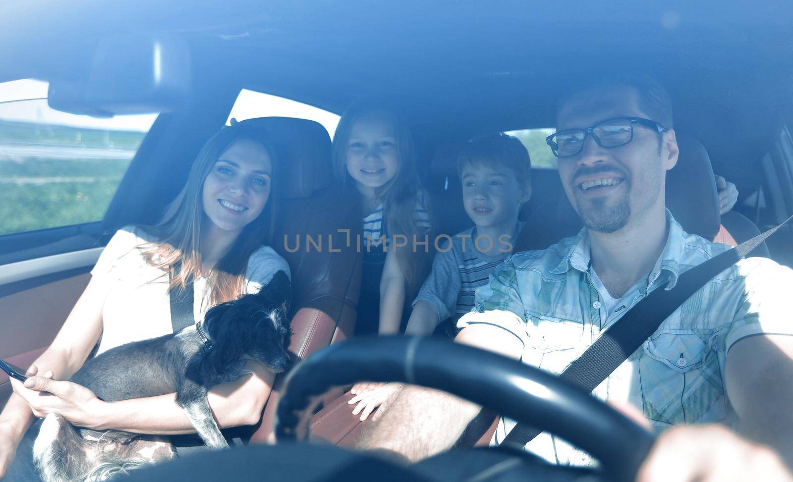 family with two children traveling in a family car by asdf