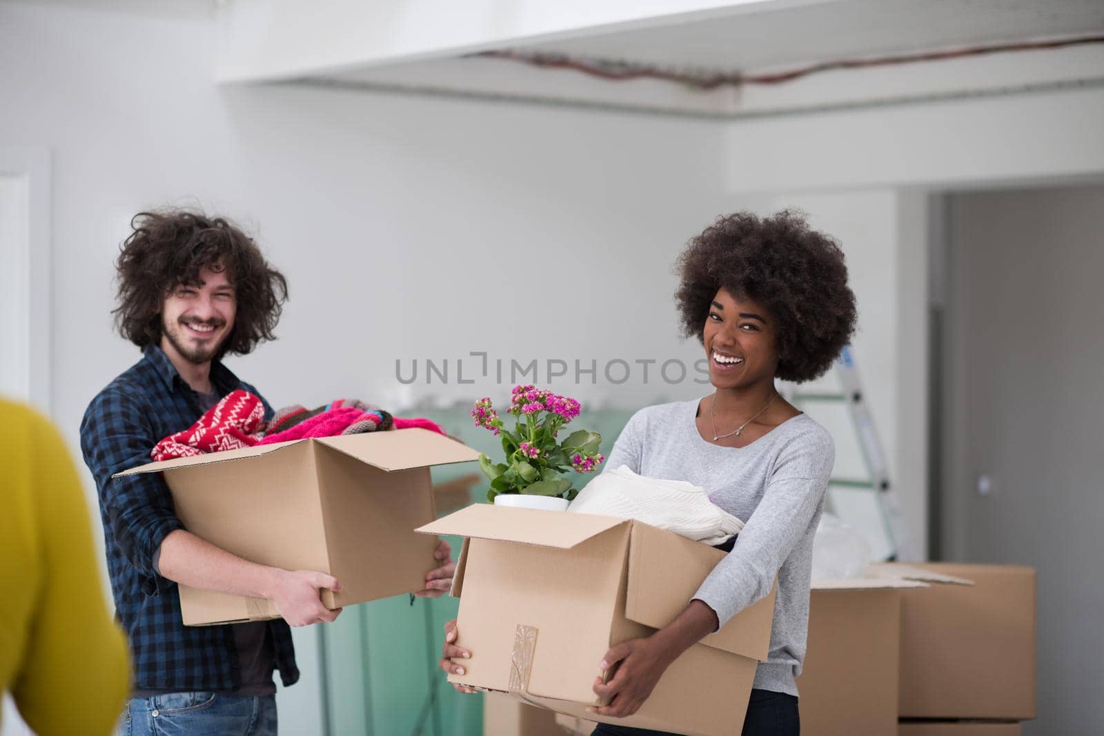 Happy young multiethnic couple unpacking or packing boxes and moving into a new home