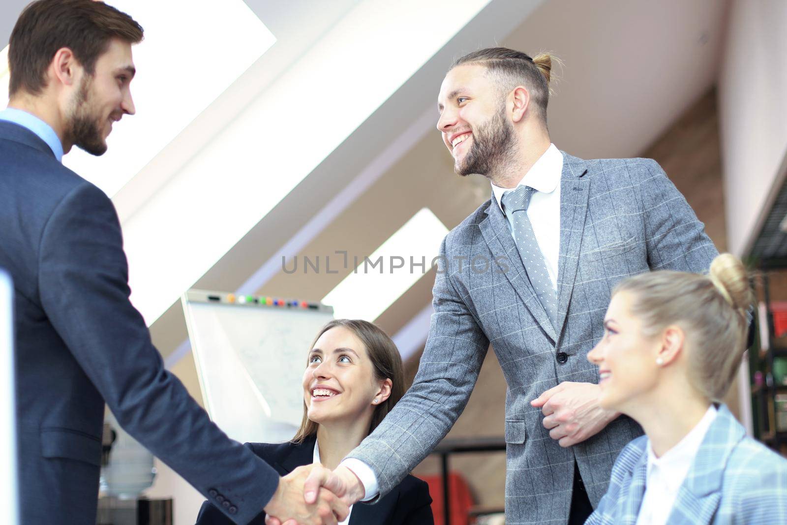 Business partners handshaking over business objects on workplace. by tsyhun