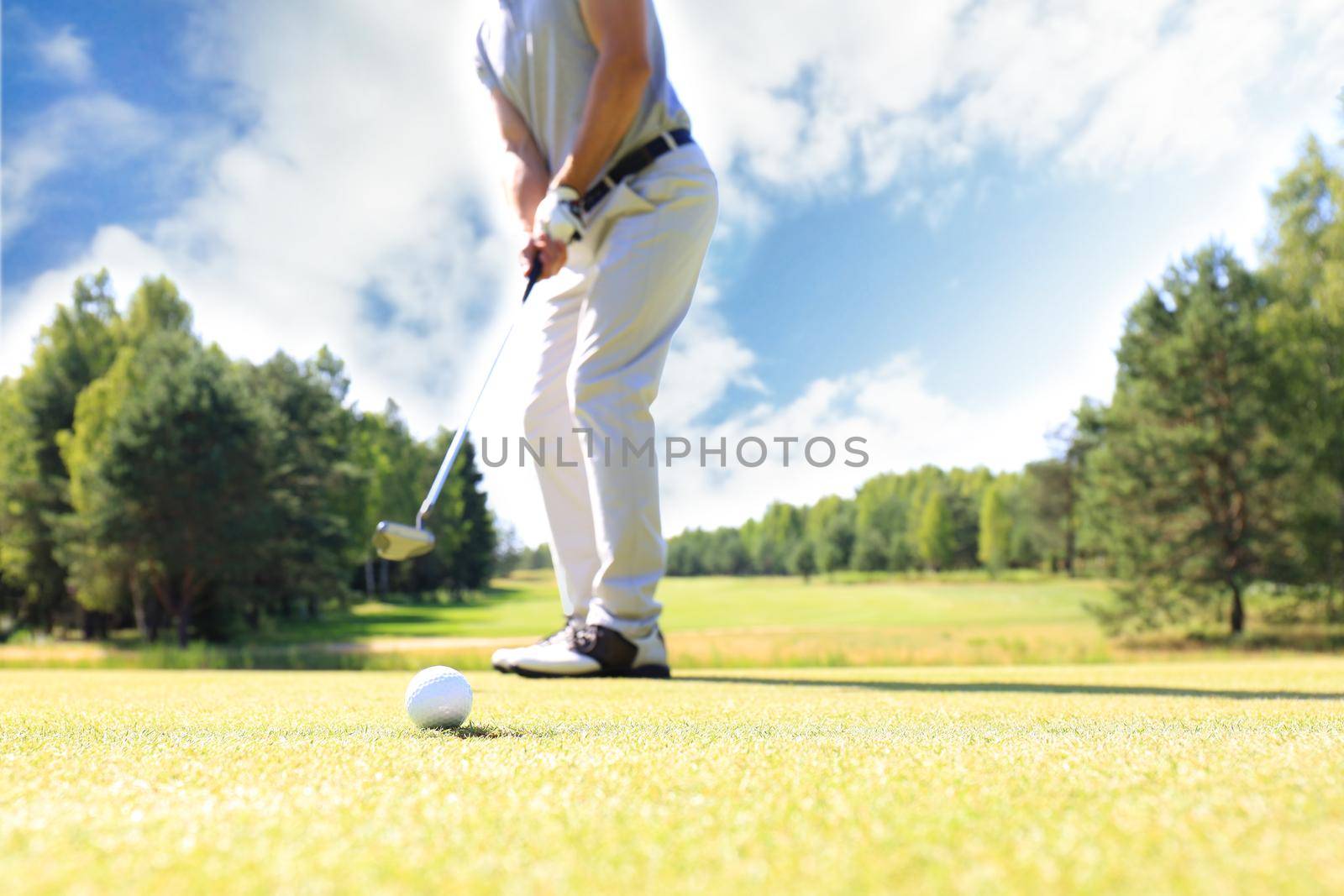 Golf approach shot with iron from fairway at sunny day. by tsyhun