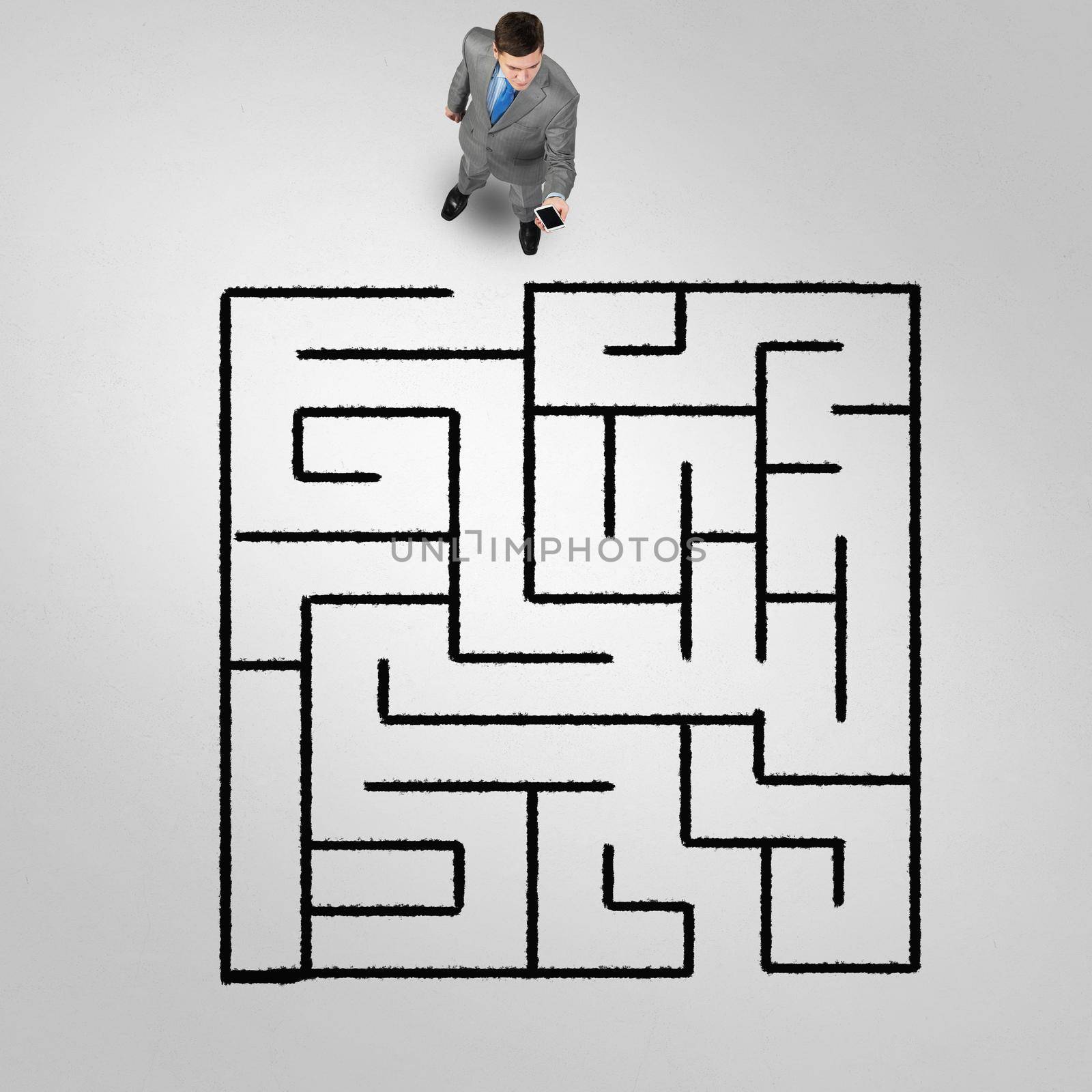 Top view of puzzled businessman looking at drawn maze on floor