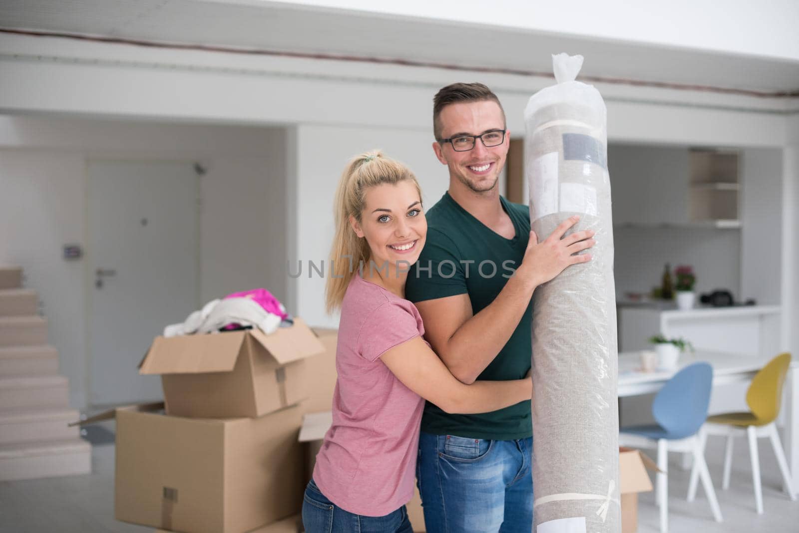 couple carrying a carpet moving in to new home by dotshock