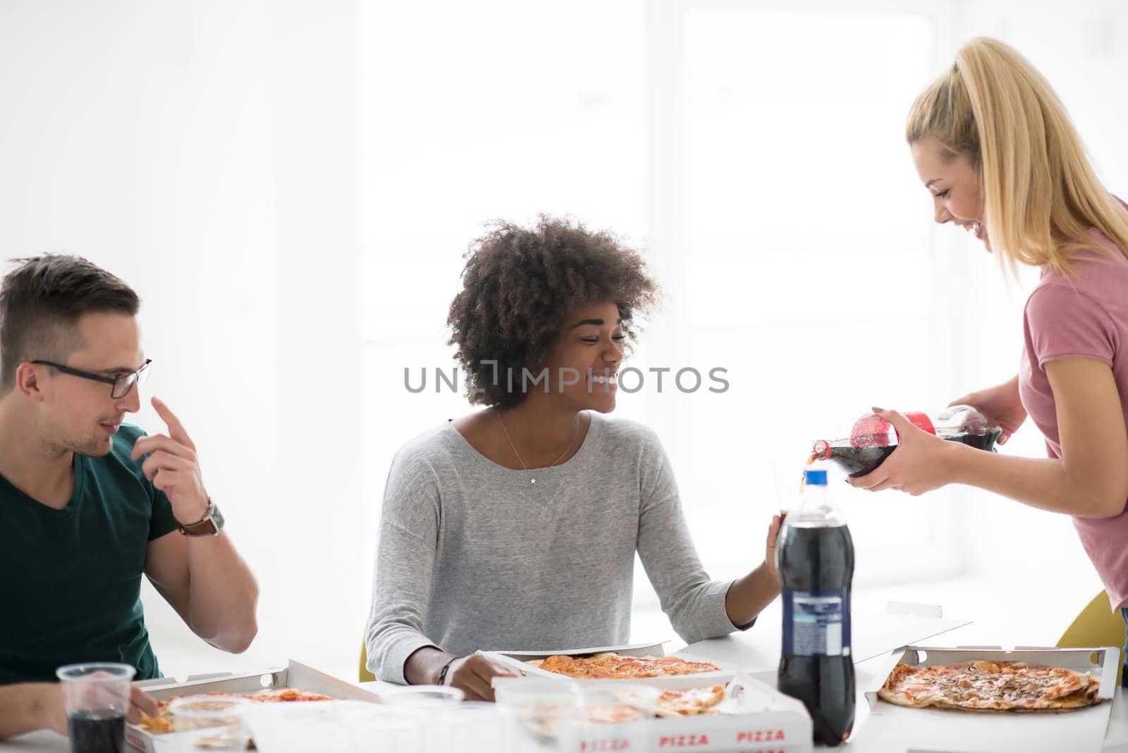 multiethnic group of young people have a lunch break after moving to a new home