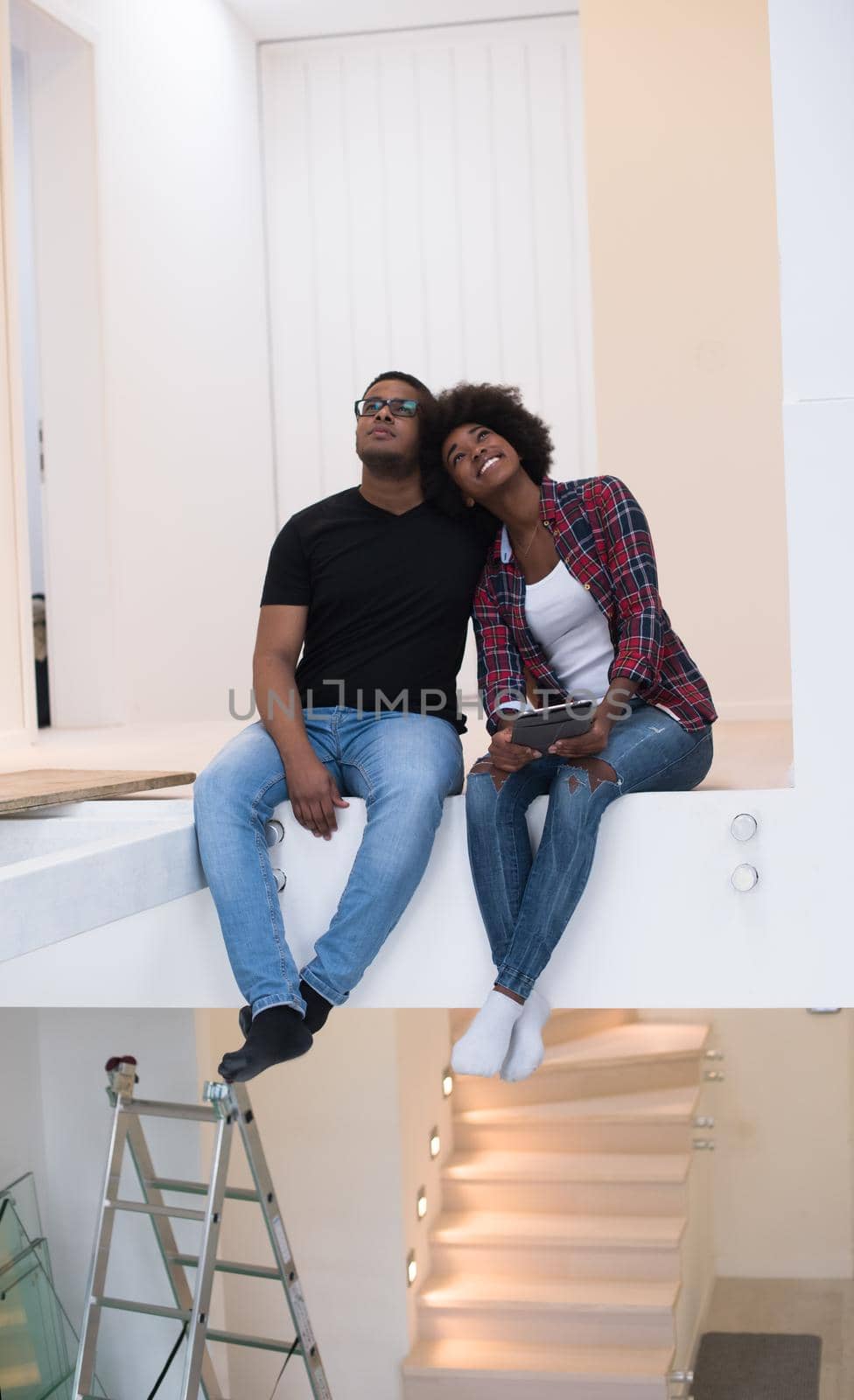 Happy young African American couple having break during moving to new house