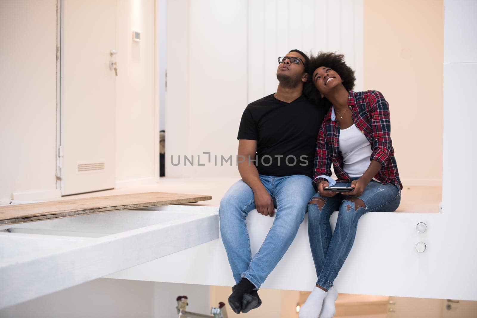 Happy young African American couple having break during moving to new house