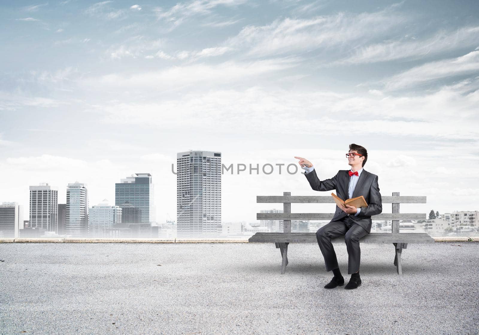 Student sits on a bench, holding a book. Traditional education concept
